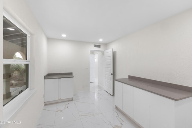 corridor with recessed lighting, visible vents, marble finish floor, and baseboards