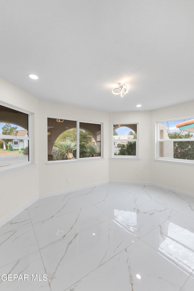 empty room with recessed lighting, marble finish floor, and baseboards