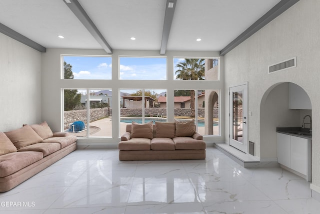 living room featuring visible vents, beam ceiling, a high ceiling, recessed lighting, and marble finish floor