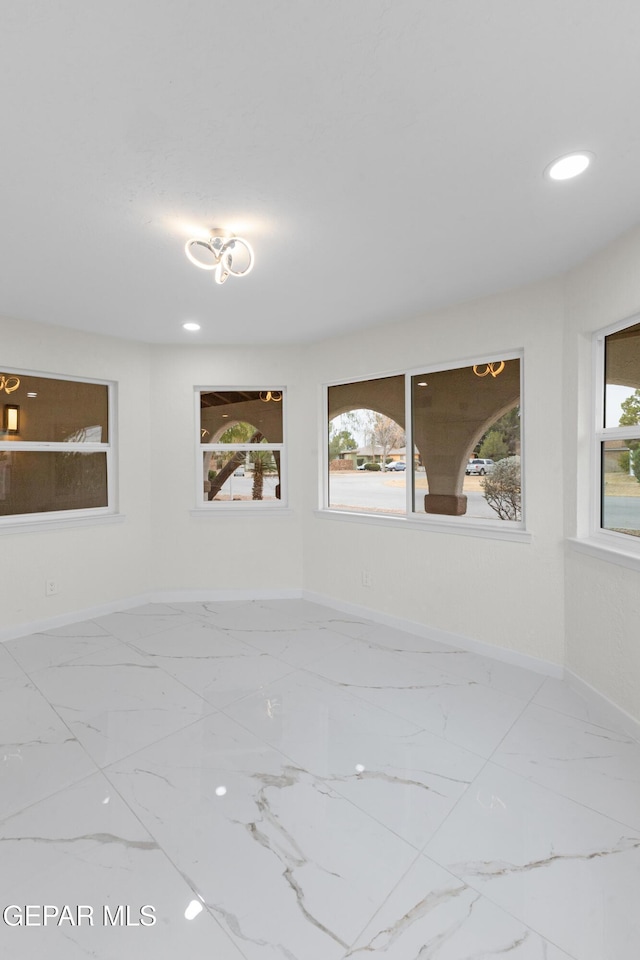 spare room featuring recessed lighting, baseboards, and marble finish floor