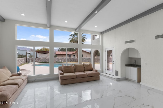 living room with a wealth of natural light, visible vents, and marble finish floor