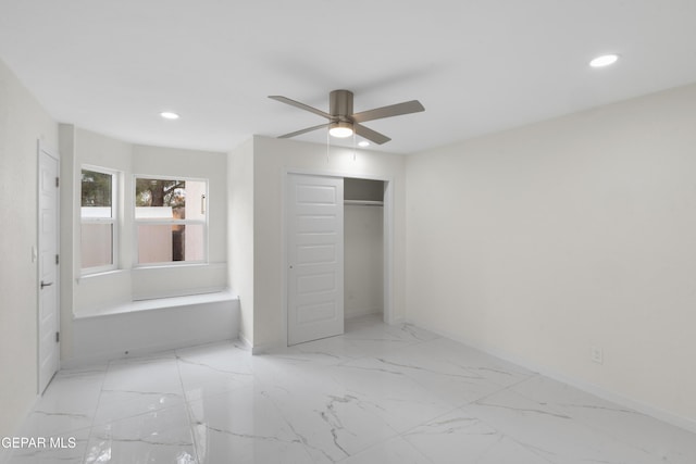 unfurnished bedroom featuring a closet, recessed lighting, marble finish floor, and baseboards