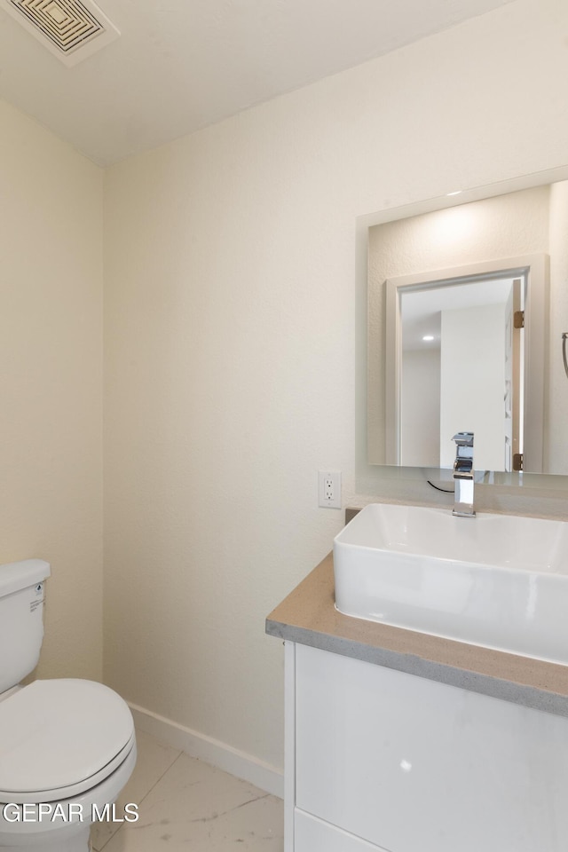 bathroom featuring vanity, toilet, baseboards, and visible vents