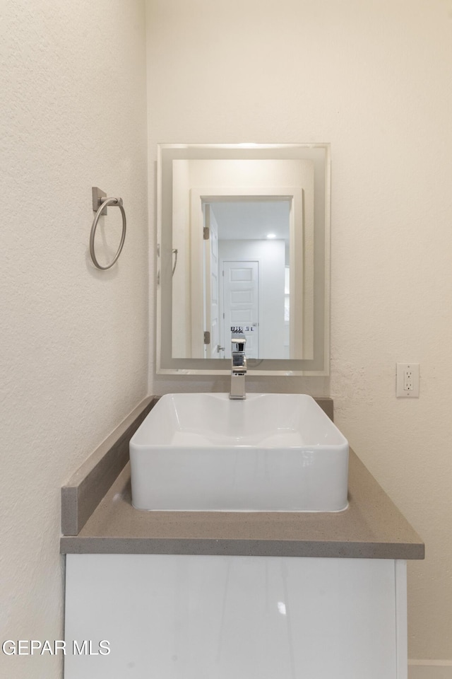 bathroom featuring a textured wall and a sink