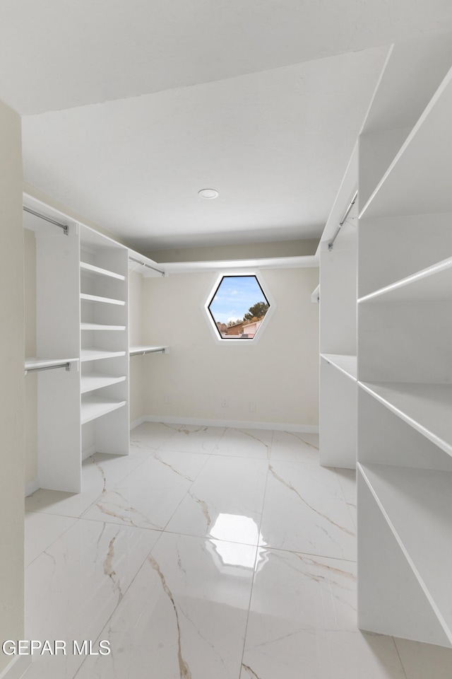 walk in closet with marble finish floor