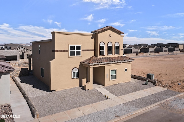 mediterranean / spanish-style house with stucco siding and a tiled roof