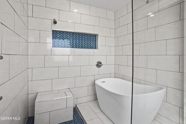 bathroom with a freestanding tub, tile walls, and a tile shower