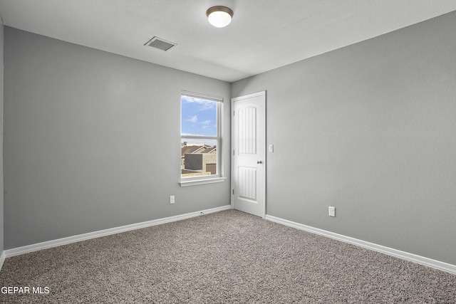 carpeted spare room featuring visible vents and baseboards