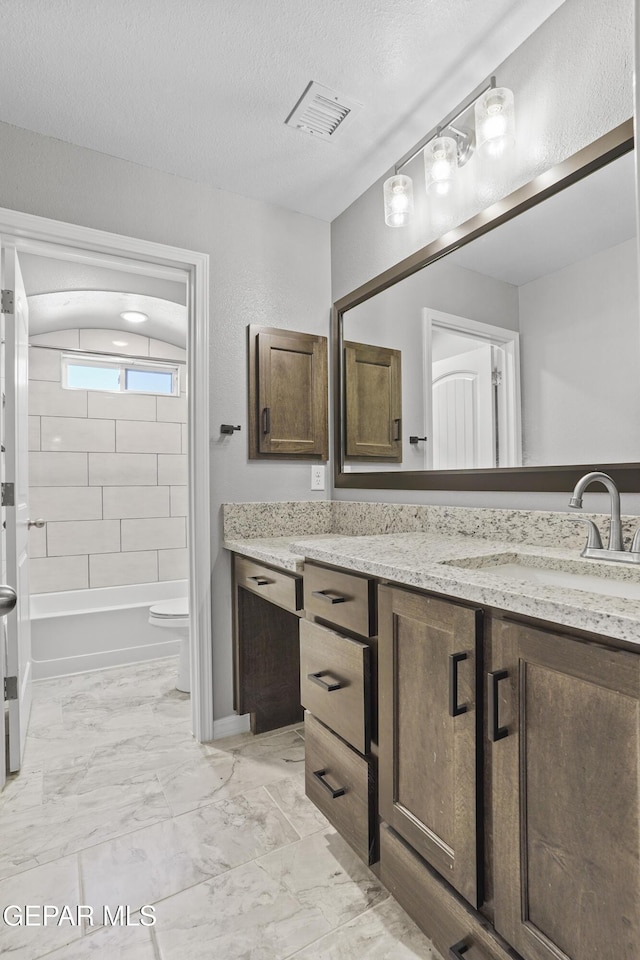 bathroom featuring vanity, visible vents, a textured ceiling, toilet, and marble finish floor