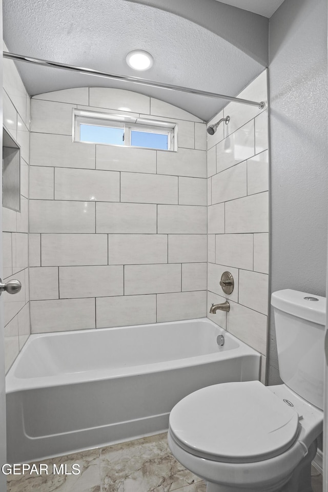 bathroom featuring a textured ceiling, toilet, shower / bath combination, and lofted ceiling