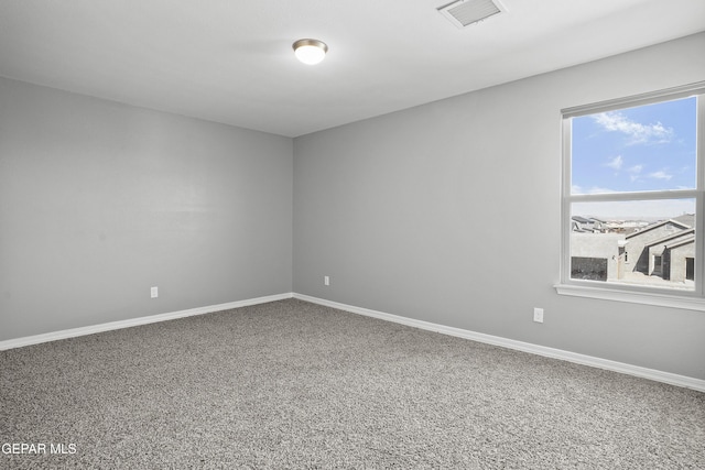 empty room with plenty of natural light, baseboards, and visible vents