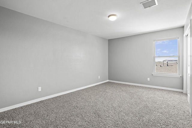 empty room featuring baseboards, visible vents, and carpet floors