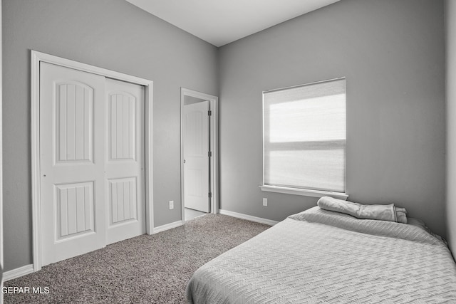 carpeted bedroom with a closet and baseboards