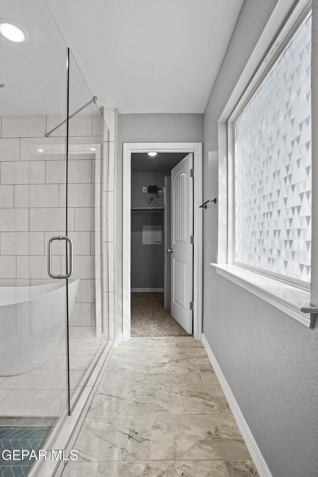 full bath with a shower stall, baseboards, and marble finish floor