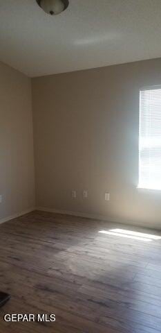 empty room with baseboards and wood finished floors