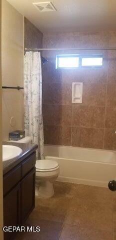 bathroom with vanity, visible vents, tile patterned flooring, shower / bath combo with shower curtain, and toilet