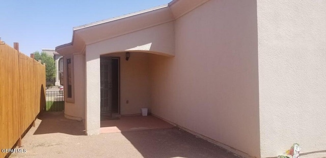 view of home's exterior with stucco siding and fence