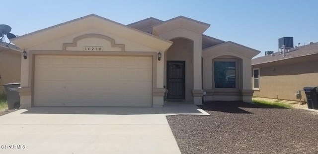 view of front of home with an attached garage, cooling unit, driveway, and stucco siding