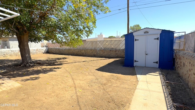 view of yard featuring an outdoor structure, a storage shed, and a fenced backyard