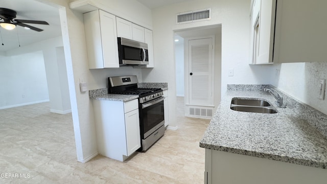 kitchen with a sink, visible vents, light stone countertops, and appliances with stainless steel finishes