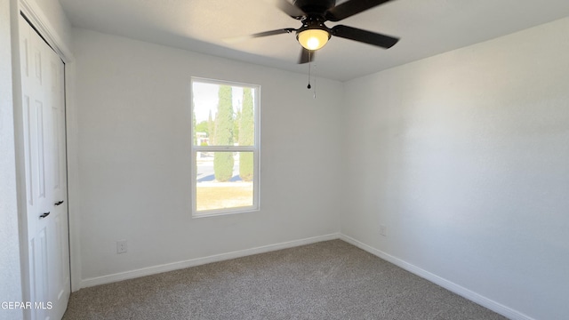 unfurnished bedroom with a closet, carpet flooring, a ceiling fan, and baseboards