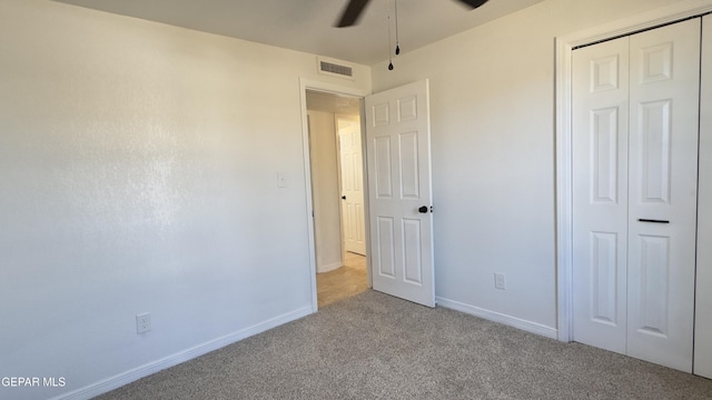 unfurnished bedroom with a closet, visible vents, baseboards, and carpet