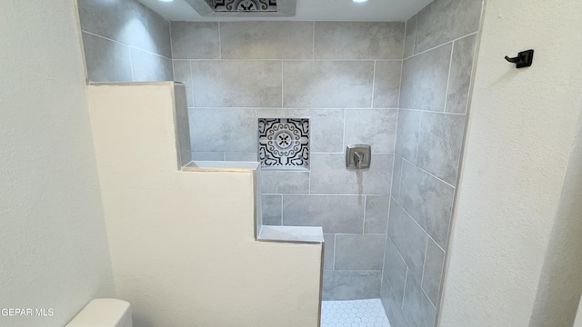 full bathroom featuring toilet and a tile shower