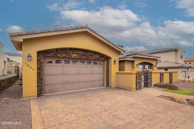 view of front of home featuring fence, stucco siding, a garage, stone siding, and decorative driveway