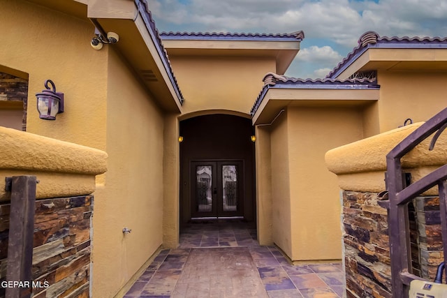 property entrance featuring french doors and stucco siding