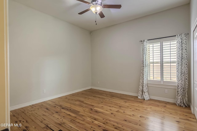 empty room featuring baseboards, wood-type flooring, and a ceiling fan