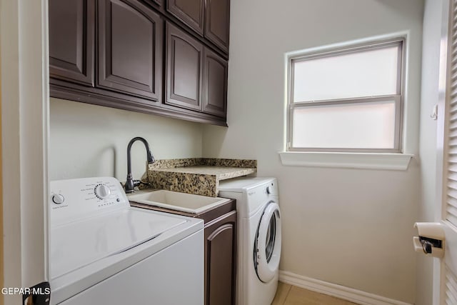 washroom with cabinet space, independent washer and dryer, and baseboards