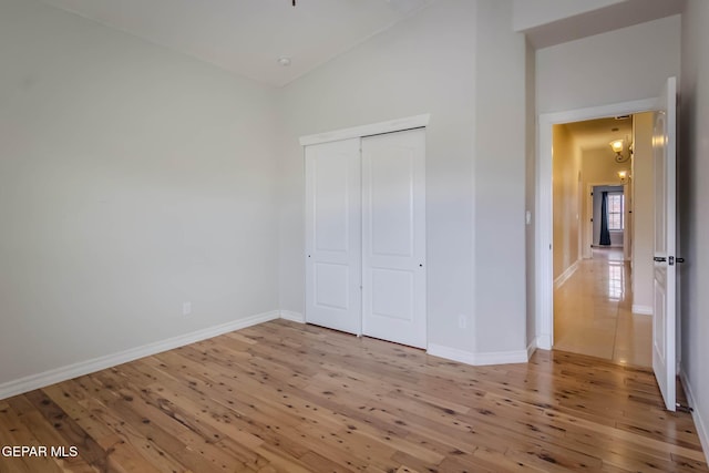 unfurnished bedroom with a closet, baseboards, and hardwood / wood-style flooring