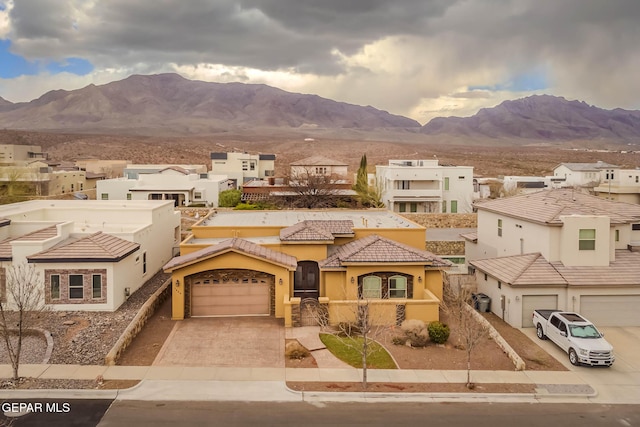 view of front of house featuring a residential view, a tiled roof, stucco siding, driveway, and a mountain view