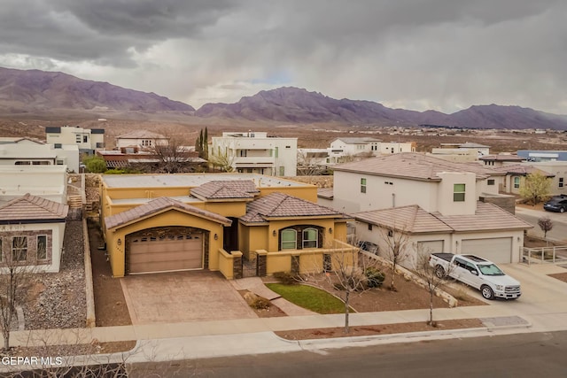 view of front of house featuring stucco siding, driveway, a mountain view, a garage, and a tiled roof