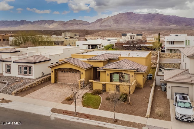 multi unit property with a tiled roof, a mountain view, driveway, and stucco siding