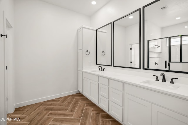 bathroom featuring visible vents, a stall shower, baseboards, and a sink