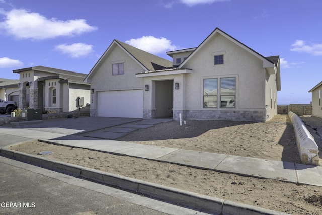 view of front of home featuring stone siding, stucco siding, concrete driveway, and a garage