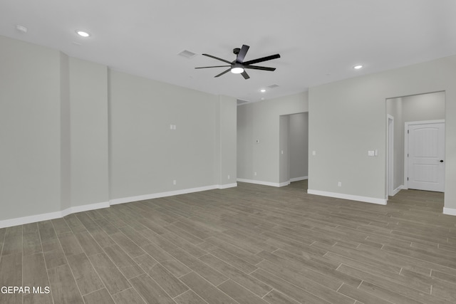 unfurnished room featuring ceiling fan, visible vents, baseboards, and wood finished floors