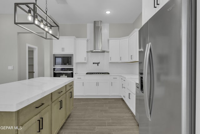 kitchen featuring wood tiled floor, stainless steel appliances, white cabinets, wall chimney exhaust hood, and a center island