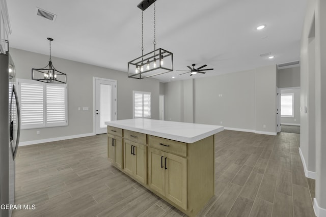 kitchen with visible vents, light countertops, freestanding refrigerator, and light wood-style floors