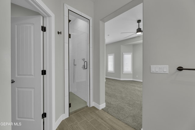 corridor featuring wood finished floors and baseboards