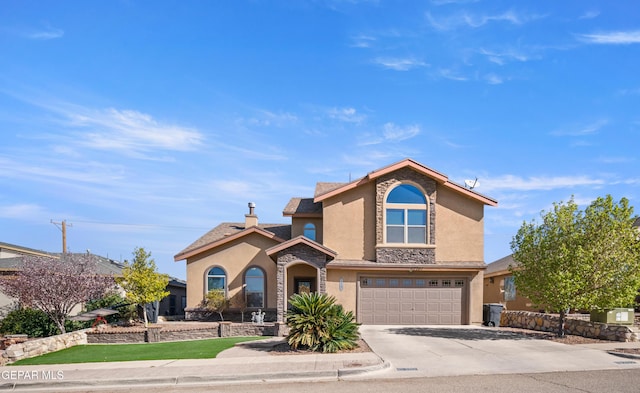 traditional-style home with stucco siding, stone siding, a garage, and driveway