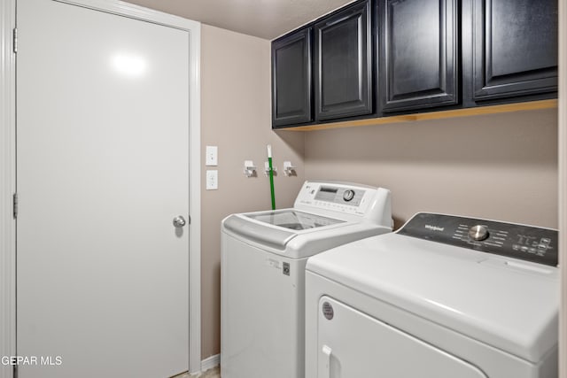 clothes washing area featuring washer and dryer and cabinet space