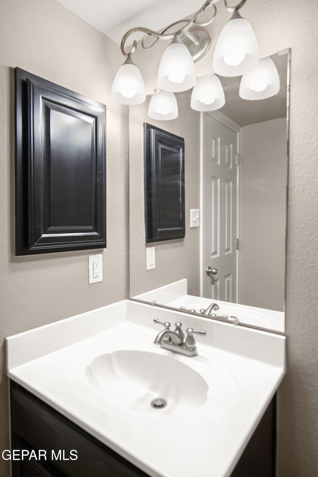 bathroom with vanity and a textured wall