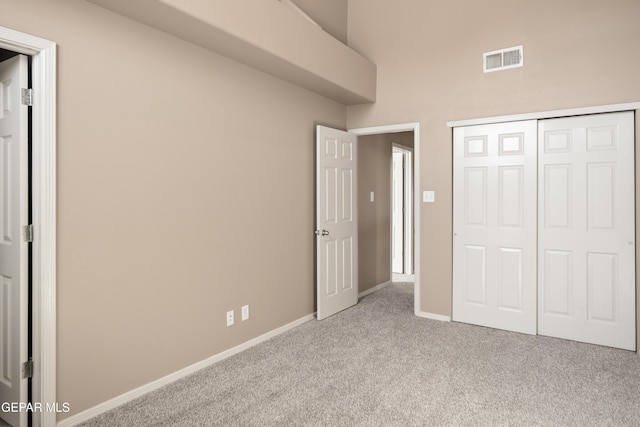 unfurnished bedroom with a closet, visible vents, baseboards, and carpet