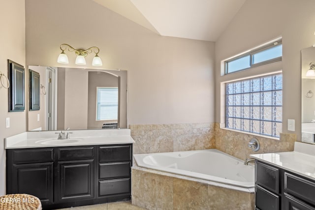 bathroom featuring a sink, lofted ceiling, two vanities, and a bath