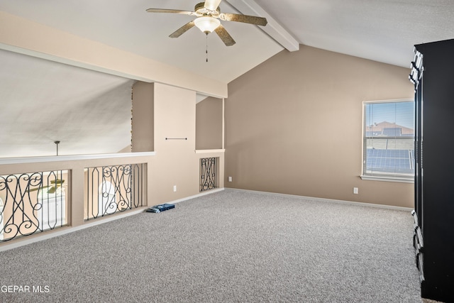 spare room with plenty of natural light, carpet, ceiling fan, and vaulted ceiling with beams