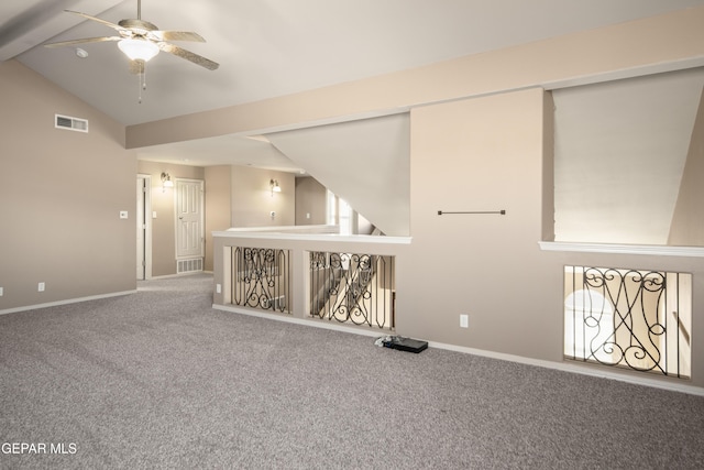 unfurnished room featuring lofted ceiling, carpet, visible vents, and baseboards