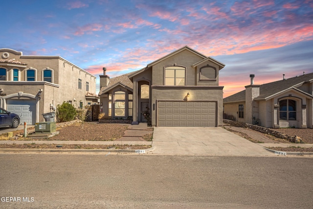 view of front facade featuring stucco siding, concrete driveway, and a garage