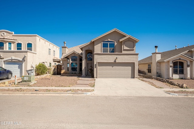 view of front of house with a garage, concrete driveway, and stucco siding